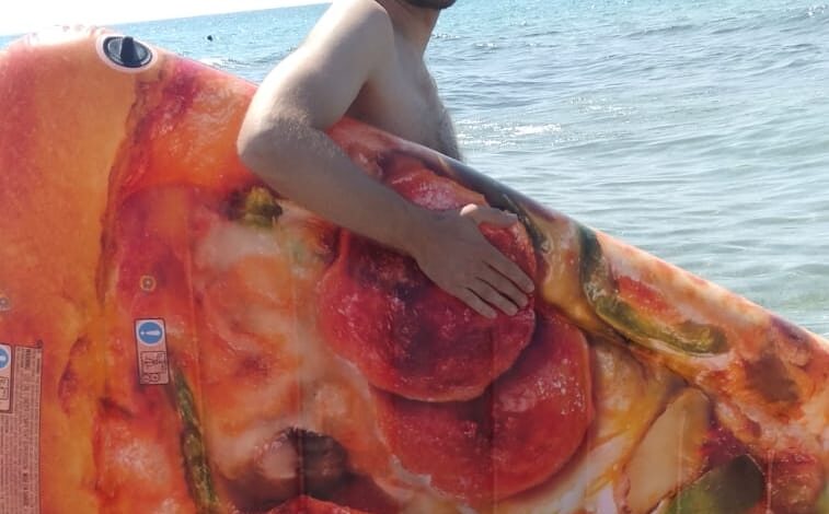 Mirco con una mega fetta di pizza in plastica